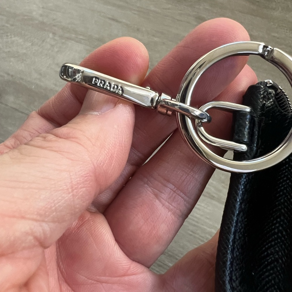 snap-hook and ring
Zipper closure
Enameled metal triangle logo
Two card slots - Picture 3 of 11